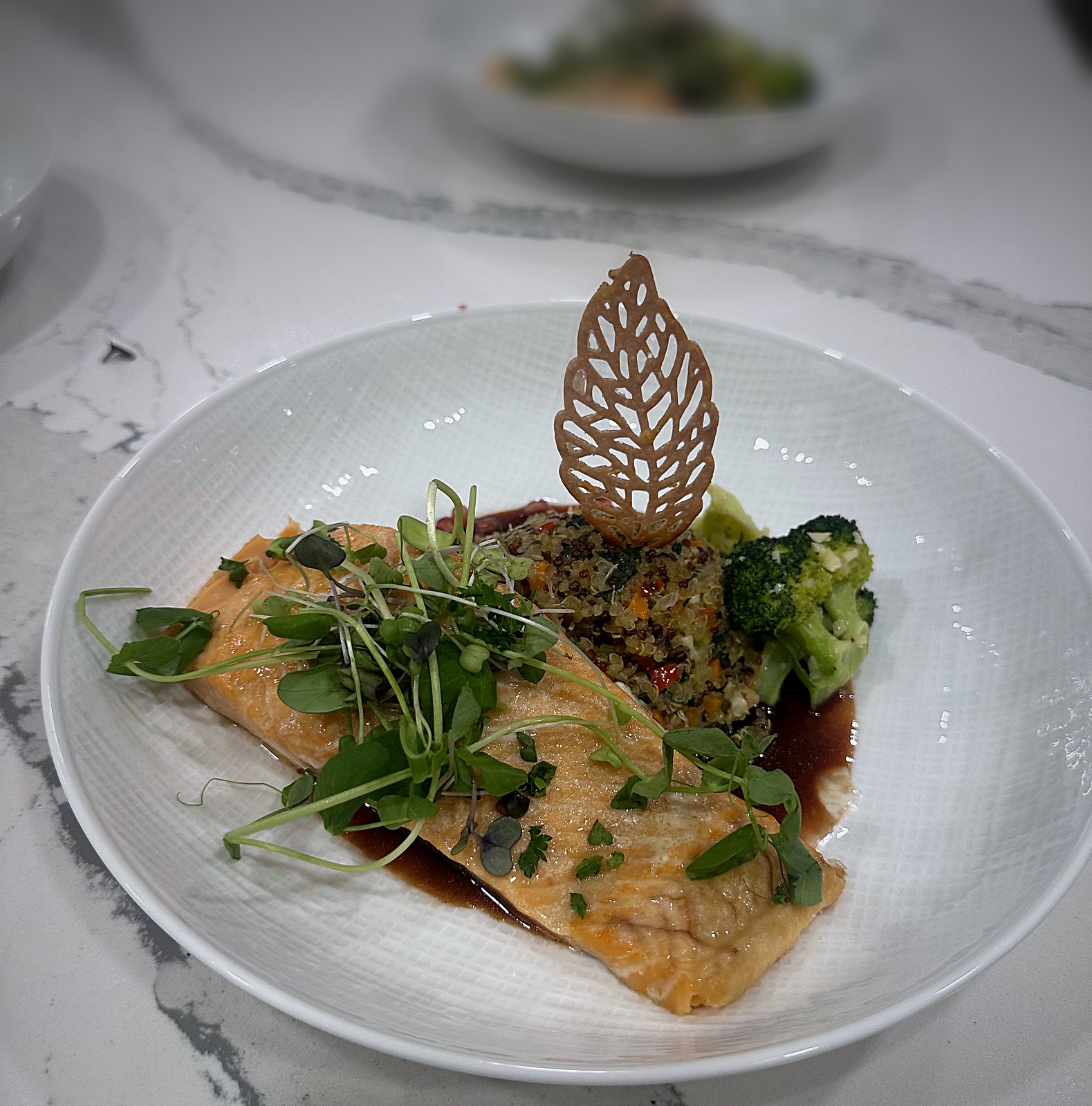 Salmon with microgreens and a leaf tuile